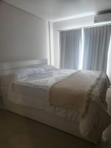 a white bed in a bedroom with a window at Cerca Trova in San Rafael
