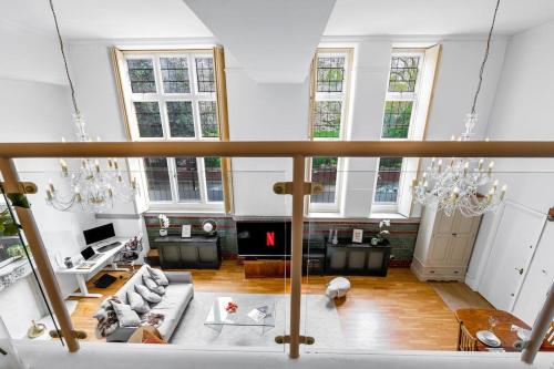 uma ampla sala de estar com um sofá e um lustre em 3BDR Extremely rare luxury loft maisonette em Londres