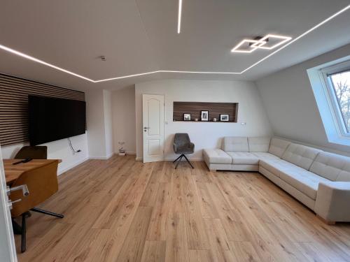 a living room with a white couch and a flat screen tv at Kurpark Oase in Bad Lippspringe