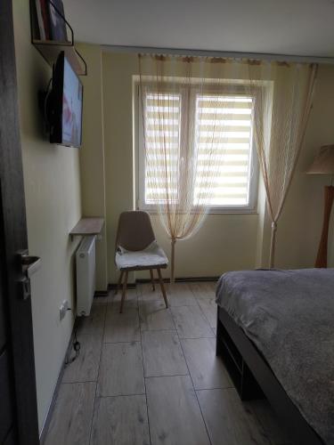 a bedroom with a bed and a chair and a window at Like People in Krakow