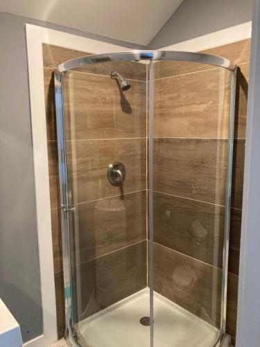 a shower with a glass enclosure in a bathroom at The GREEN Tiny House in Houston
