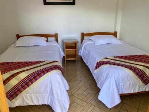 two beds sitting next to each other in a room at El Oasis de Dorita in Caraz