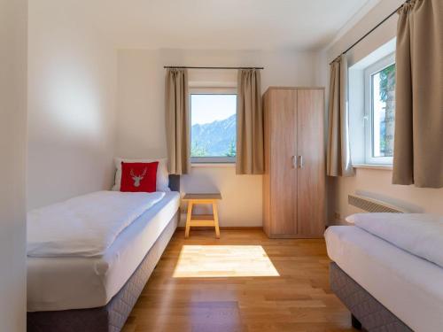 a small room with two beds and a window at Villa Taube XL in Bad Gastein