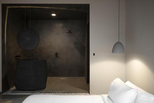 a bedroom with a bed and a shower in a room at kodō hotel - Heart of LA Arts District in Los Angeles