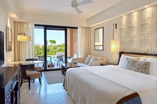 a bedroom with a large bed and a living room at The Romanos, a Luxury Collection Resort, Costa Navarino in Romanós