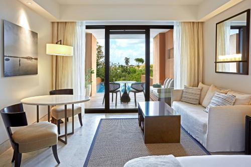 a living room with a couch and a table at The Romanos, a Luxury Collection Resort, Costa Navarino in Romanós