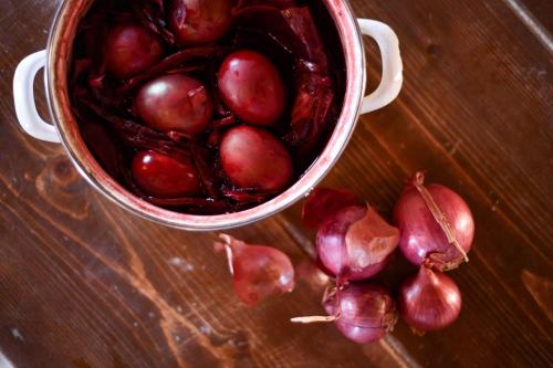 a bucket of red onions on a wooden table at The Romanos, a Luxury Collection Resort, Costa Navarino in Romanós
