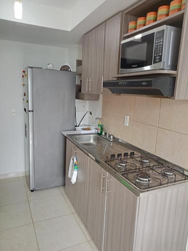 La cuisine est équipée d'un réfrigérateur en acier inoxydable et d'un four micro-ondes. dans l'établissement apartamento amoblado norte de armenia, à Hojas Anchas