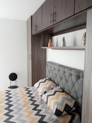 - une chambre avec un lit avec une tête de lit et une chaise dans l'établissement apartamento amoblado norte de armenia, à Hojas Anchas