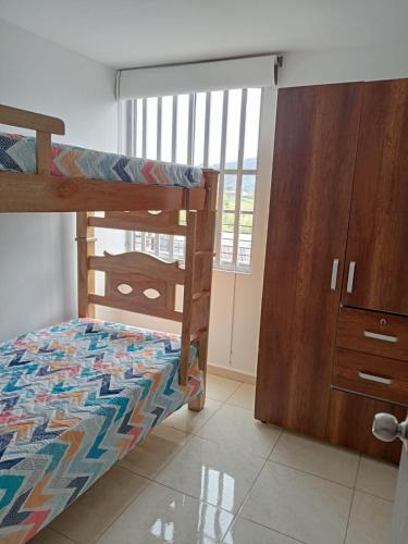 - une chambre avec des lits superposés et une commode dans l'établissement apartamento amoblado norte de armenia, à Hojas Anchas