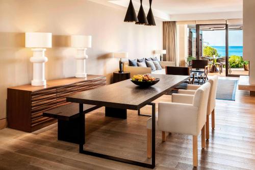 a living room with a dining table and a living room at The Romanos, a Luxury Collection Resort, Costa Navarino in Romanós