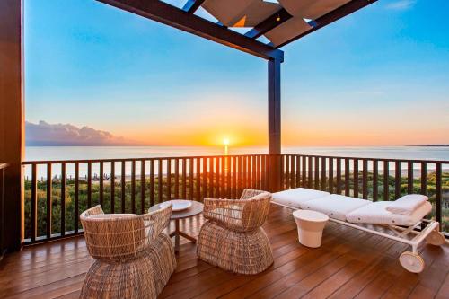 a porch with chairs and a couch on a deck with a view at The Romanos, a Luxury Collection Resort, Costa Navarino in Romanós