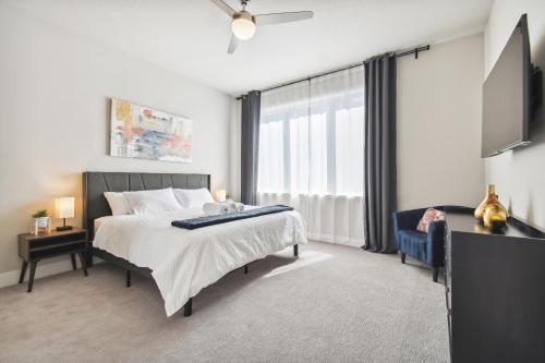 a bedroom with a bed and a flat screen tv at Stunning New Condo Close to Disney World in Kissimmee