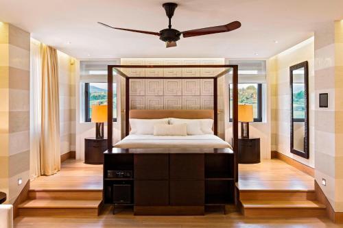 a bedroom with a bed and a ceiling fan at The Romanos, a Luxury Collection Resort, Costa Navarino in Romanós