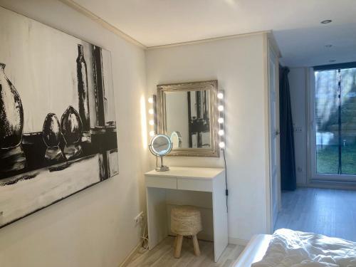 um quarto com um espelho, um toucador e uma cama em 8-person house with fitted kitchen, sauna, and beautiful garden em Oostmahorn