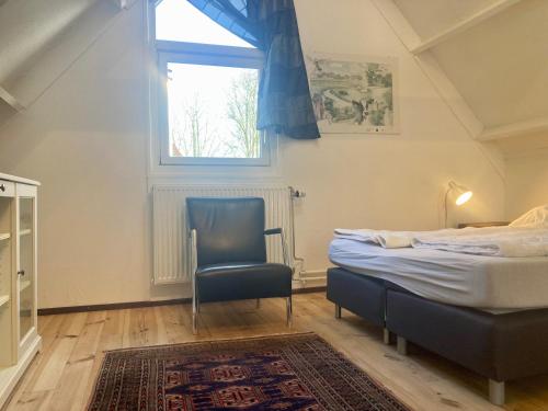 - une chambre avec un lit, une chaise et une fenêtre dans l'établissement 8-person house with fitted kitchen, sauna, and beautiful garden, à Oostmahorn