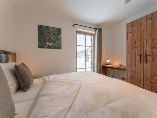 a bedroom with a white bed and a window at Haus Enzian in Donnersbachwald