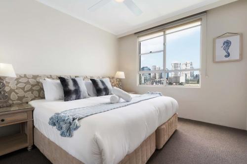 a bedroom with a large bed and a window at Harbourside #53 in Sydney