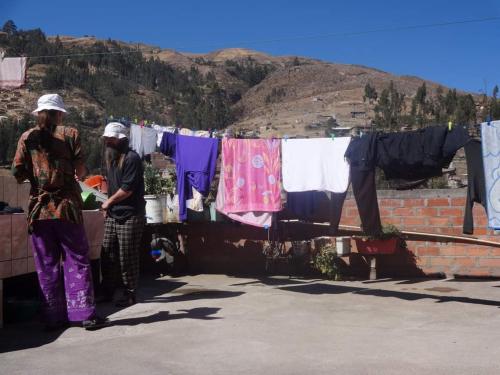 two women standing in front of a clothes line with clothes at Villa hospedaje in Huaraz