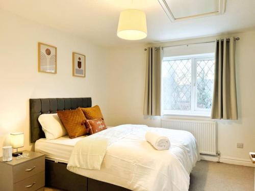 a bedroom with a large white bed with a window at Vista Lodge in Wythenshawe