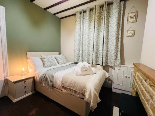 a bedroom with a bed with two towels on it at The Naunton Nook in Cheltenham