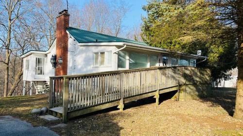 una casa con un porche con una valla en Tranquil Coastal Escape en Port Stanley