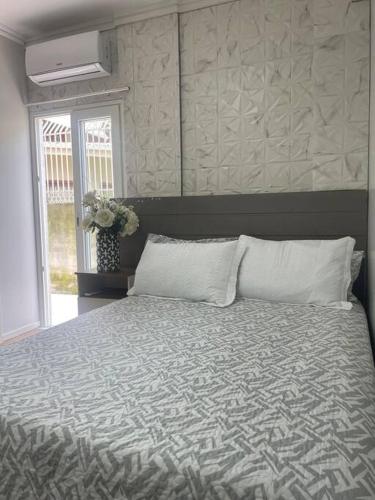 - une chambre avec un lit doté d'une couette et d'une fenêtre dans l'établissement Residencial Descanso Casal, à Criciúma