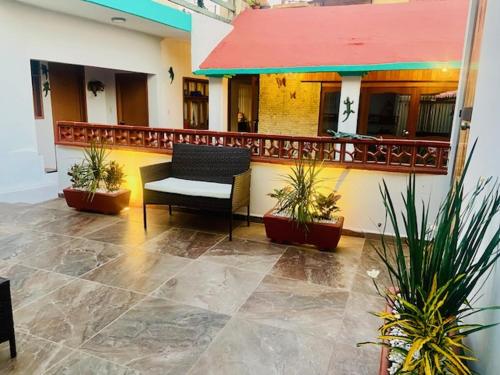 a balcony of a building with a chair and plants at CASA JOAQUÍN HOSTAL in Oaxaca City