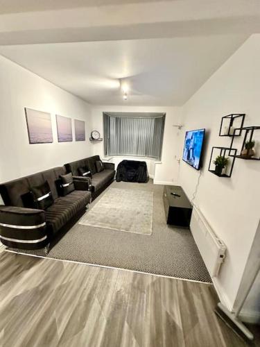 a living room with a couch and a television at Cosy 3 Bed Apartment,Free Parking in Birmingham in Birmingham