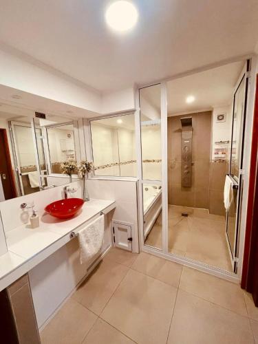 a bathroom with a red sink and a shower at Peatonal Suites Paraná in Paraná