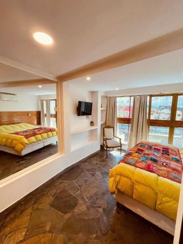 - une chambre avec 2 lits et une télévision dans l'établissement Peatonal Suites Paraná, à Paraná