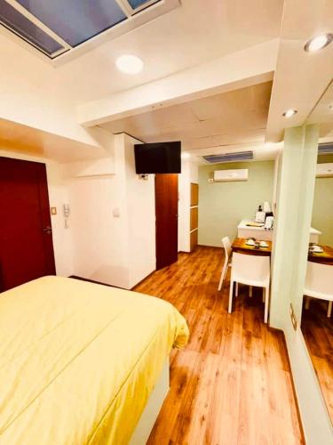 a bedroom with a bed and a table and a desk at Peatonal Suites Paraná in Paraná
