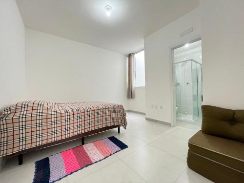 Cette chambre blanche dispose d'un lit et d'un canapé. dans l'établissement Apenas 650m da praia - Balneário Piçarras, à Balneário Piçarras