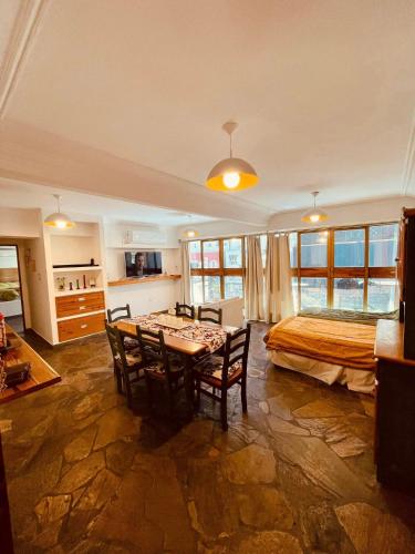 Peatonal Suites Paraná في بارانا: غرفة نوم بسرير وطاولة وكراسي