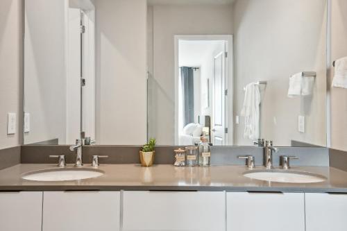 a bathroom with two sinks and a large mirror at Stunning New Condo Close to Disney World in Kissimmee