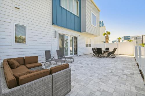 a patio with a couch and chairs in front of a house at Stunning New Condo Close to Disney World in Kissimmee