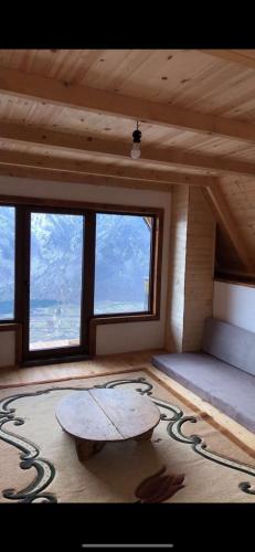 Zimmer mit einem Tisch in einem Zimmer mit Fenstern in der Unterkunft Lindja e Diellit in Bulqizë