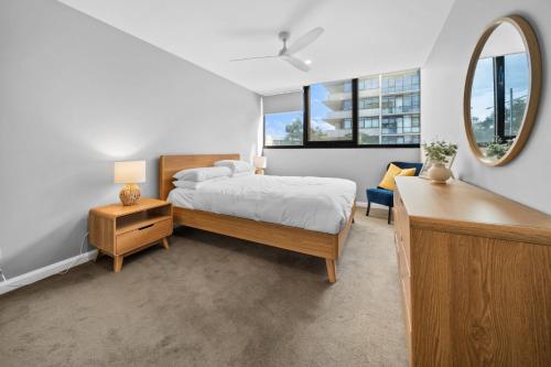 a bedroom with a bed and a large mirror at Impeccably Chic 3-Bed Apartment Just Outside CBD in Campbell