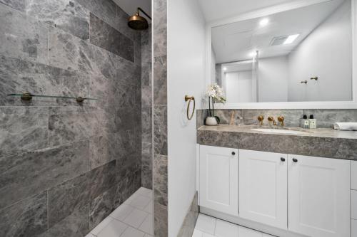 a bathroom with a sink and a mirror at Impeccably Chic 3-Bed Apartment Just Outside CBD in Campbell