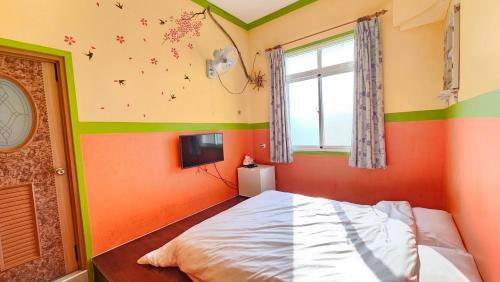 a bedroom with orange and green walls and a bed at Sea Front Homestay in Magong