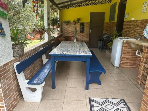 een blauwe tafel en een bank op een patio bij Casa no campo in Bom Jardim