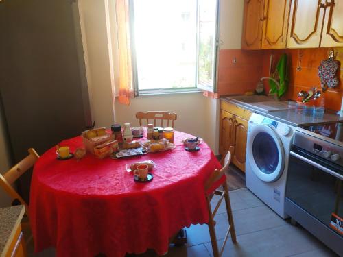 a kitchen with a table with a red table cloth at Vatican Trastevere house Rome in Rome