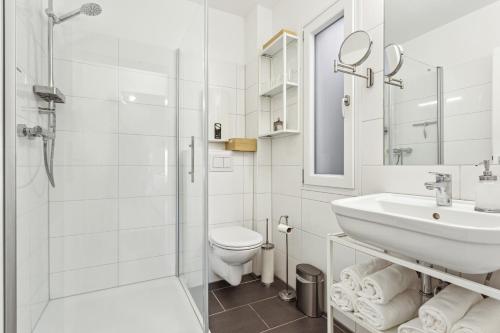 ein weißes Bad mit einem Waschbecken und einem WC in der Unterkunft Luxus Apartment Lüdinghausen in Lüdinghausen