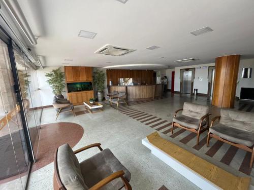 ヴィラ・ヴェーリャにあるFlats beira mar - praia da costaの広いリビングルーム(椅子、テーブル付)