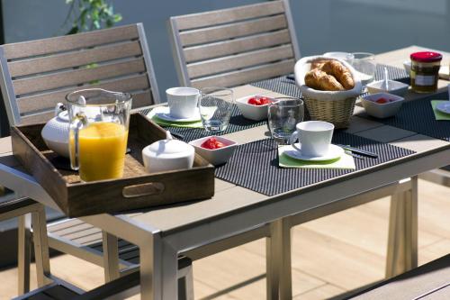 une table avec un plateau de nourriture et de jus d'orange dans l'établissement La Terrasse des Climats, à Beaune