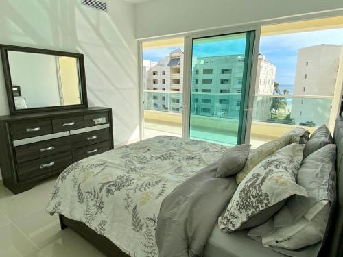 a bedroom with a bed and a dresser and a window at Villa parmera ocean from in Los Corrales