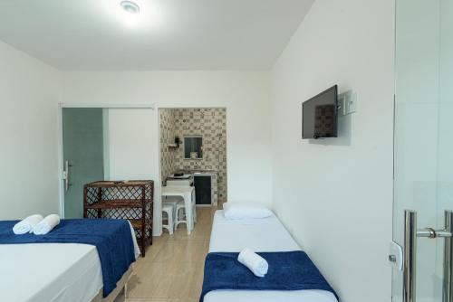 Habitación pequeña con 2 camas y cocina en Flats Ledy en Cairu