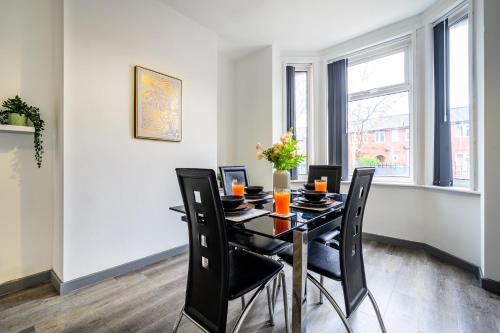 a dining room with a black table and chairs at Manchester Serviced Accommodation NorthernNightzzz - The Park in Manchester