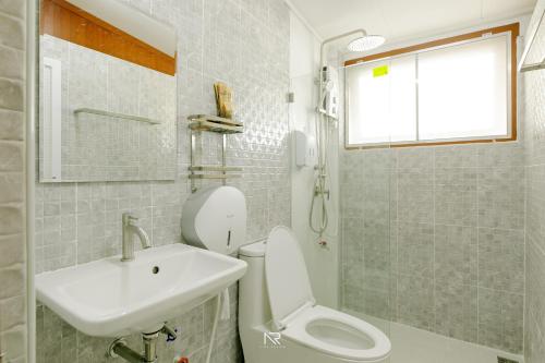 White house 36 Hatyai في هات ياي: حمام به مرحاض أبيض ومغسلة