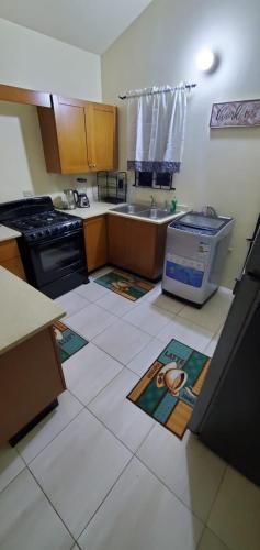 a kitchen with a sink and a stove at Finest Accommodation Phoenix Park Phase 1 Lot 74 Portmore St Catherine in Portmore